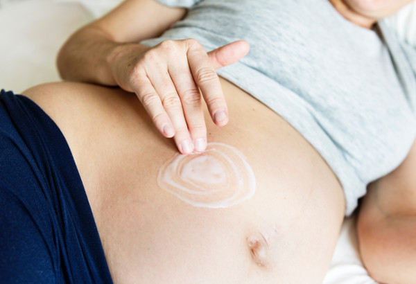 Bild: Schwangere Frau massiert ihren Bauch
