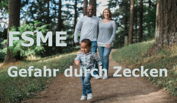 FSME Mutter hält Baby mit Superman-Strampler im Wald hoch,